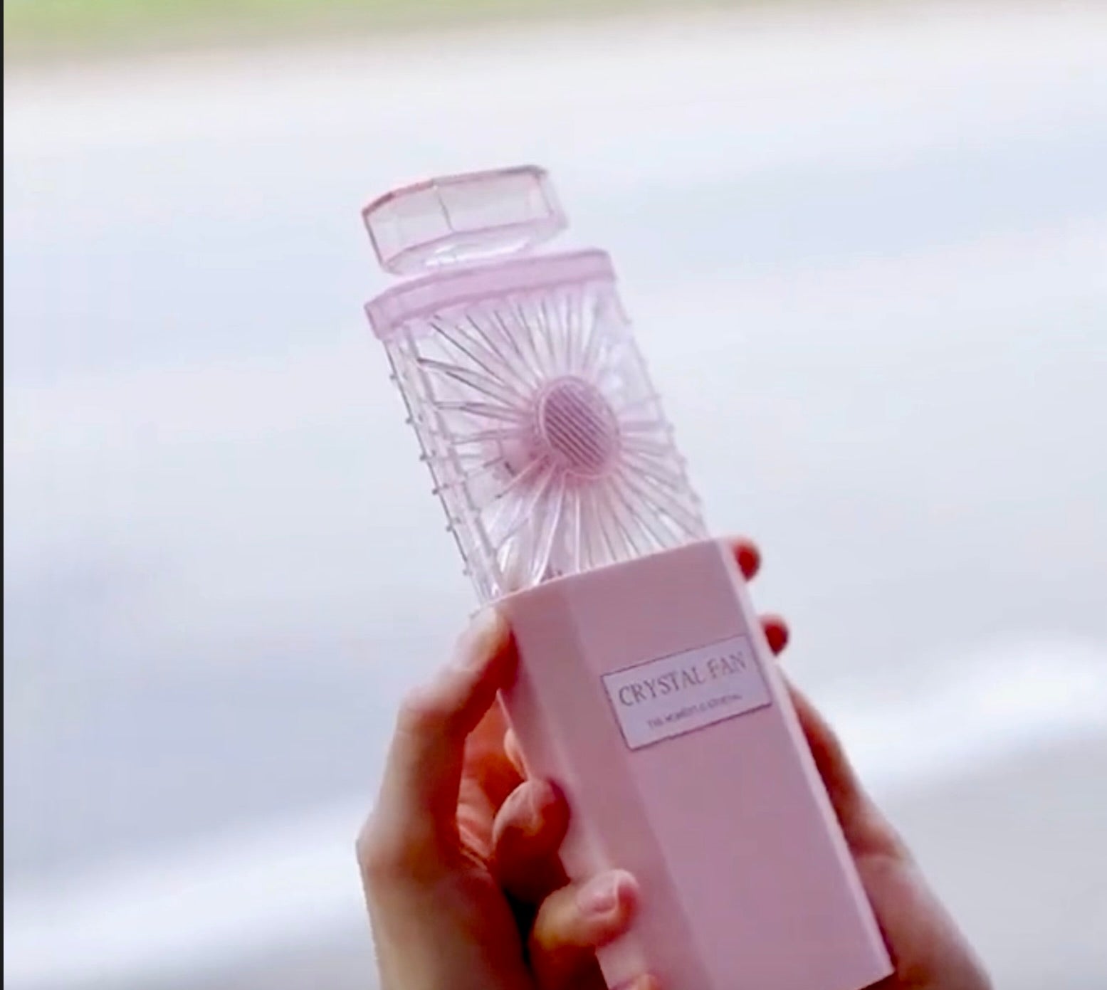 Load video: Crystal Perfume Fan cools down a lady on a hot day and she applies her favorite favorite to the housing unit on the fan for long lasting scent all day